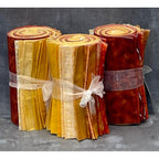 Three rolls of fabric in red, orange, and yellow with ribbons on a textured gray background